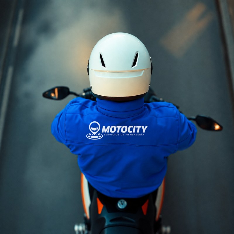 Motorista Motocity de espaldas, vista aérea, con la chaqueta corporativa Motocity